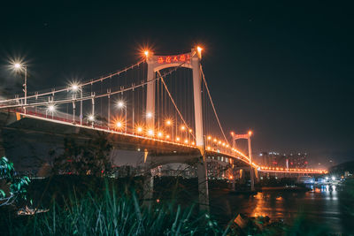 Illuminated suspension bridge at night