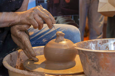 Potter making ceramic mug on the pottery wheel