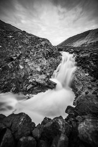 Scenic view of waterfall against sky