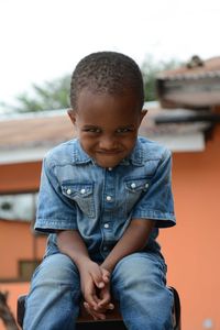 Portrait of cute boy sitting outdoors