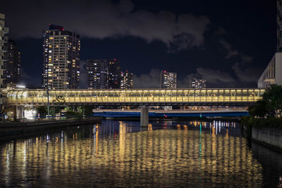 View of the footbridge connecting the buildings across the canal in yokohama during night time.