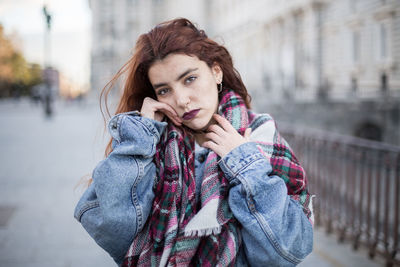Portrait of woman in warm clothes while standing in city during winter