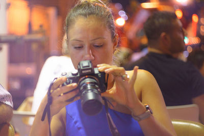 Young woman using camera at restaurant