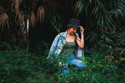 Full length of woman sitting on land