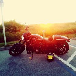 Motorcycle on road against sky during sunset