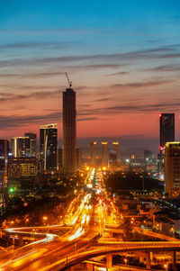 Illuminated buildings in city against sky at night