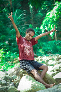 Full length of boy playing with arms raised standing in sea