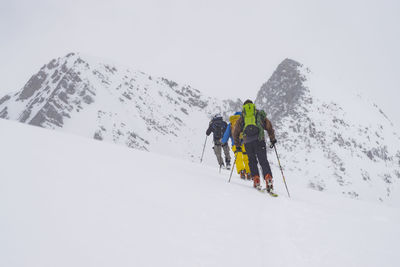 Low angle view of people skiing in snow