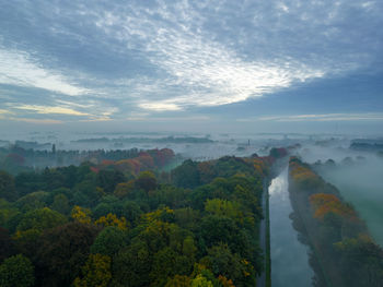 Scenic view of misty autumn landscape against sky