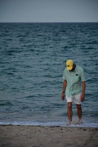 Full length of man standing at beach against sky