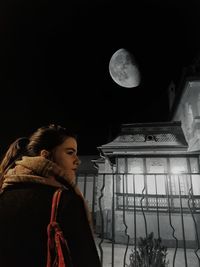 Young woman standing at night