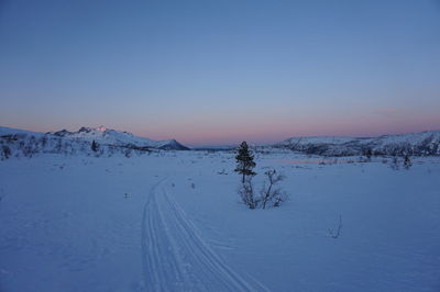 Scenic view of snow covered landscape against clear blue sky