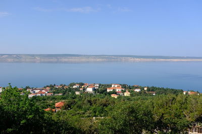 High angle view of townscape by sea against sky