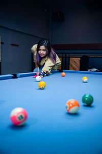 Portrait of woman playing pool