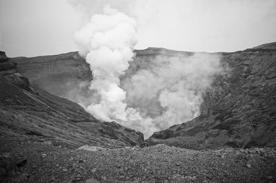 Smoke emitting from volcanic mountain against sky