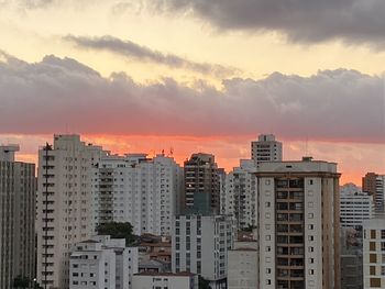 Buildings in city against sky during sunset