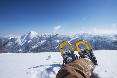 Austria, salzburg state, altenmarkt-zauchensee, man with snowshoes lying in deep snow