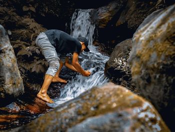 Rear view of woman looking at waterfall