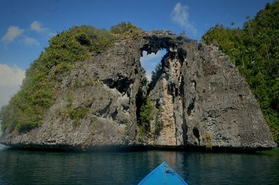 Rock formations by sea against sky