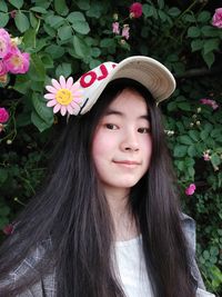 Portrait of beautiful young woman with pink flowers