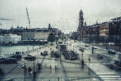 City seen through wet glass window during rainy season