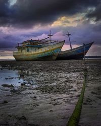 Boat moored at sea shore against sky