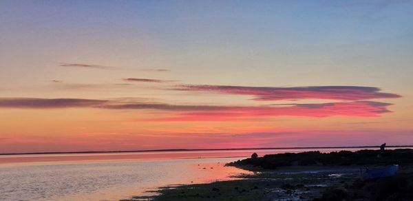 Scenic view of sea against romantic sky at sunset