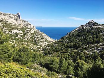 Scenic view of sea and mountains against sky