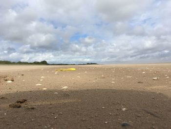 Scenic view of beach against cloudy sky