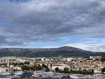 Aerial view of townscape by mountain against sky