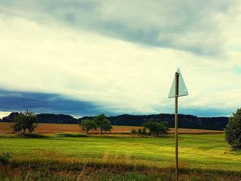 Wind turbines on field against sky