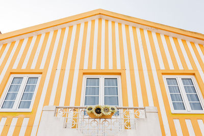 Colorful striped yellow wooden beach houses at the promenade of costa nova, aveiro, portugal
