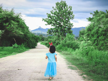 Rear view of girl walking on the road