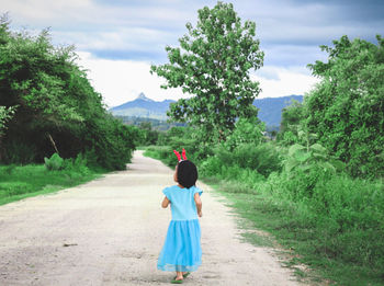 Rear view of woman walking on field