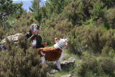 Woman with dog playing on field