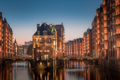 Reflection of buildings in city at waterfront