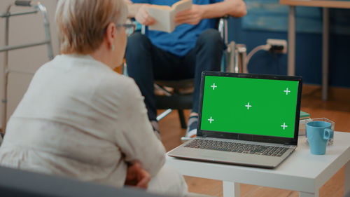 Rear view of woman looking at laptop