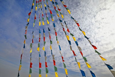 Low angle view of multi colored flags hanging against sky