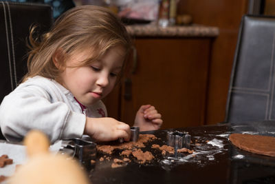 Full length of girl looking at camera on table