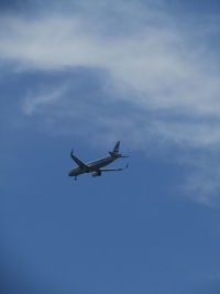 Low angle view of airplane flying against sky