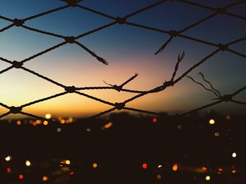 Full frame shot of broken fence against sky during sunset