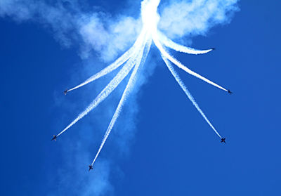 Low angle view of airplane flying against blue sky