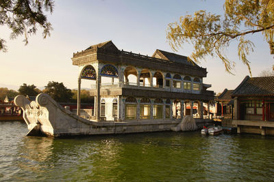 View of building by river against sky