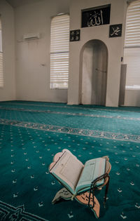 Empty chairs by swimming pool against building