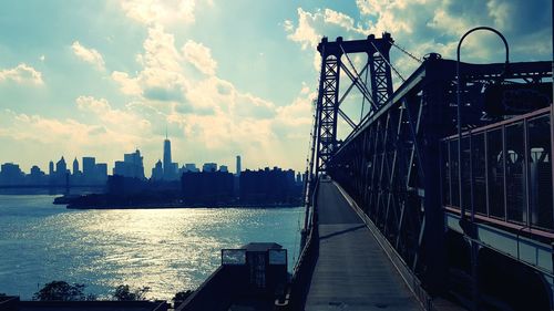 Bridge over river against cloudy sky