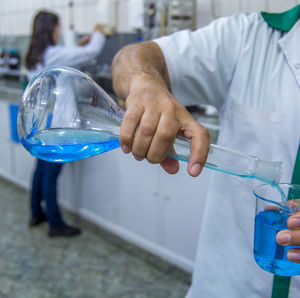 Midsection of male scientist experimenting in laboratory