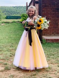 Portrait of a smiling young woman standing against wall