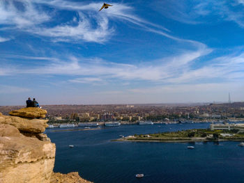 Scenic view of sea and cityscape against sky