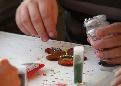 Midsection of person making gingerbread man on table