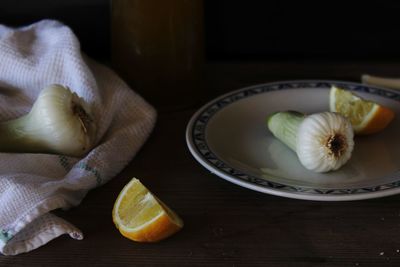 Spring onions with sliced lemons on table